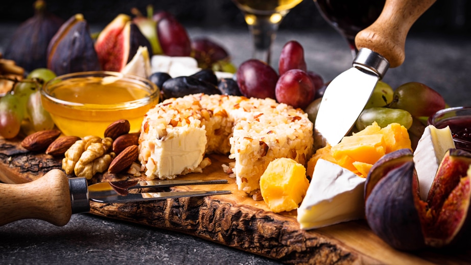 cheese platter with figs and cheese are shown
